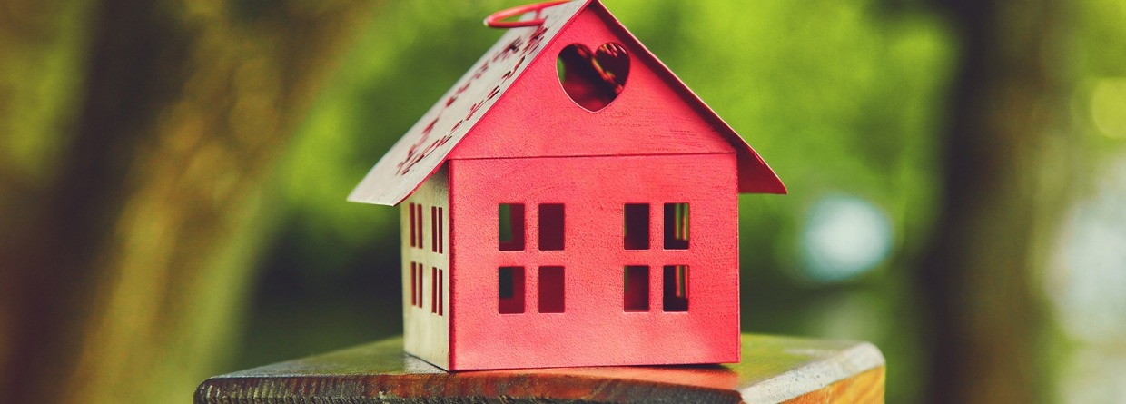 Rood model van het huis als symbool op de natuurlijke tuin achtergrond, prinsjesdag, Miljoenennota, wonen, huis, hypotheek