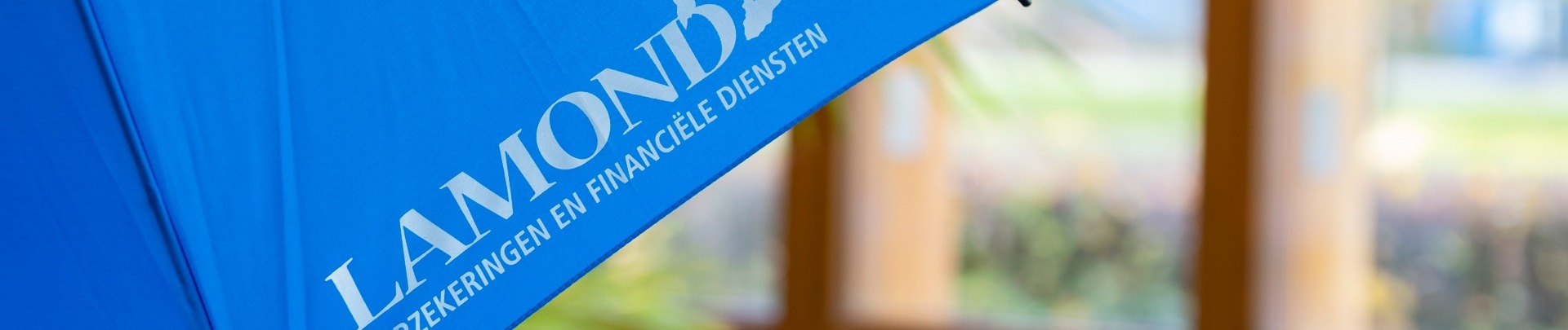 Een blauwe paraplu met daarop het logo van Lamond Verzekeringen & Financiële diensten