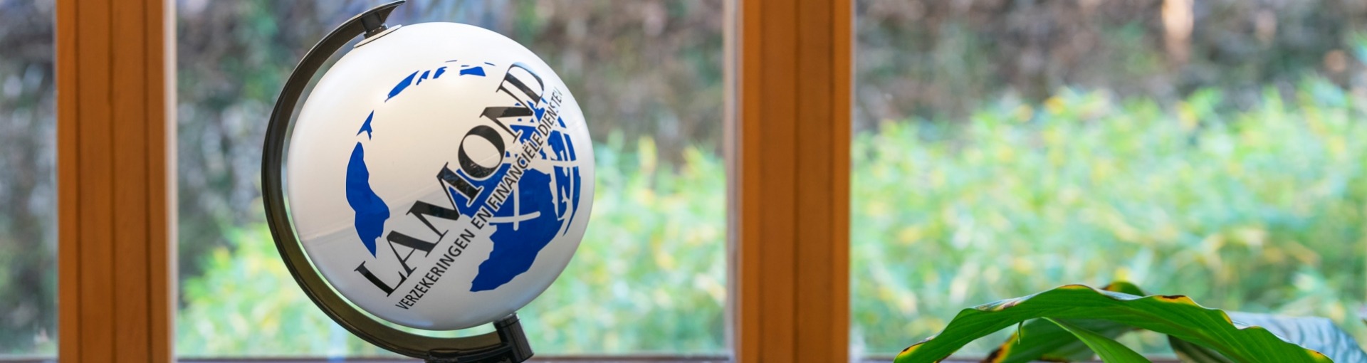 Een kleine wereldbol met daarop het logo van Lamond Verzekeringen & Financiële Diensten